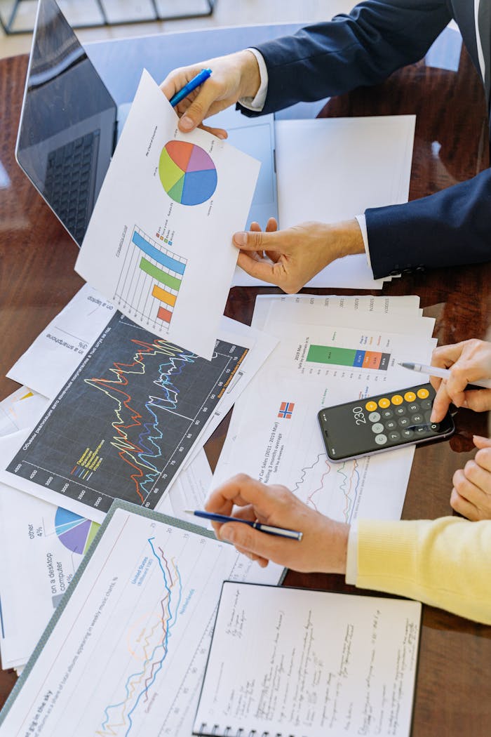 about-us Business professionals analyzing financial charts and graphs during a meeting.