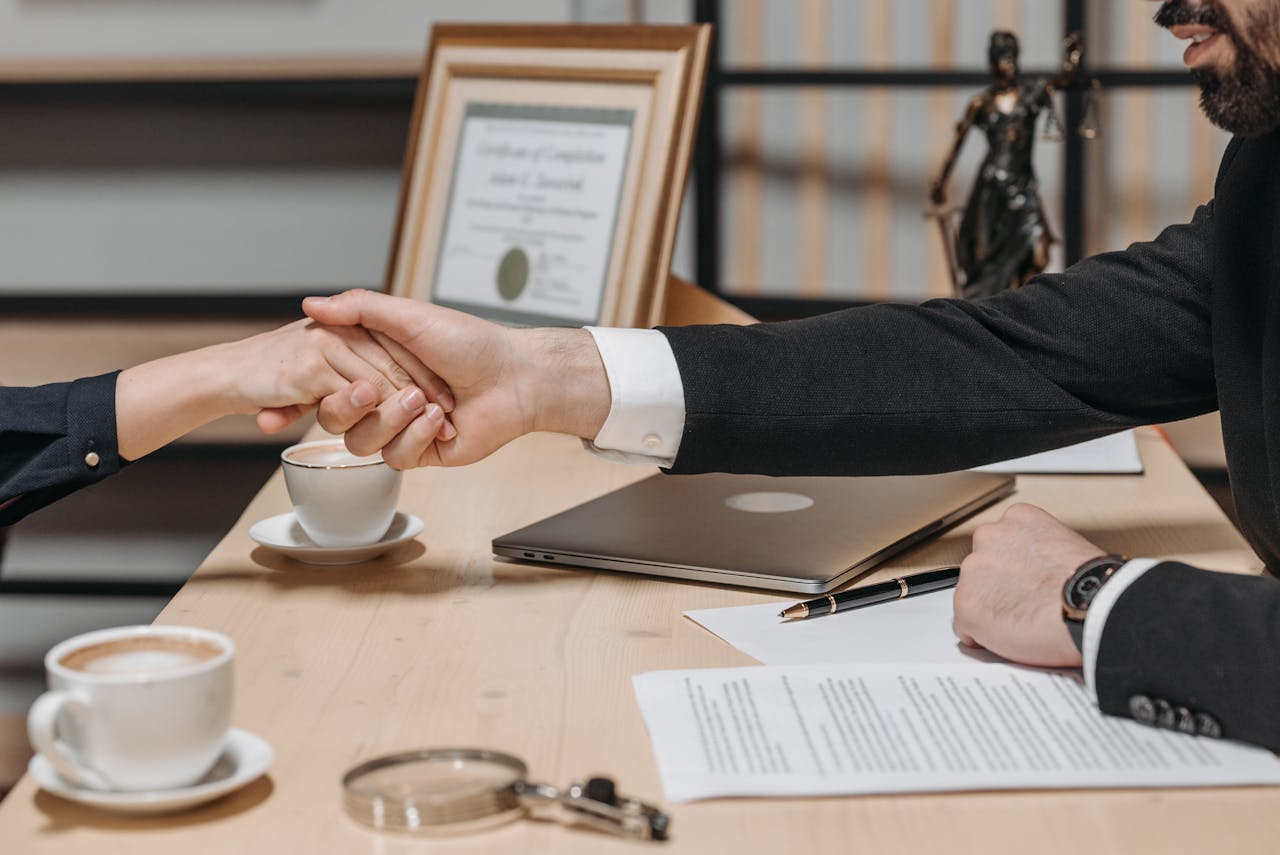 services-06 A formal handshake over a business contract in a corporate office setting.